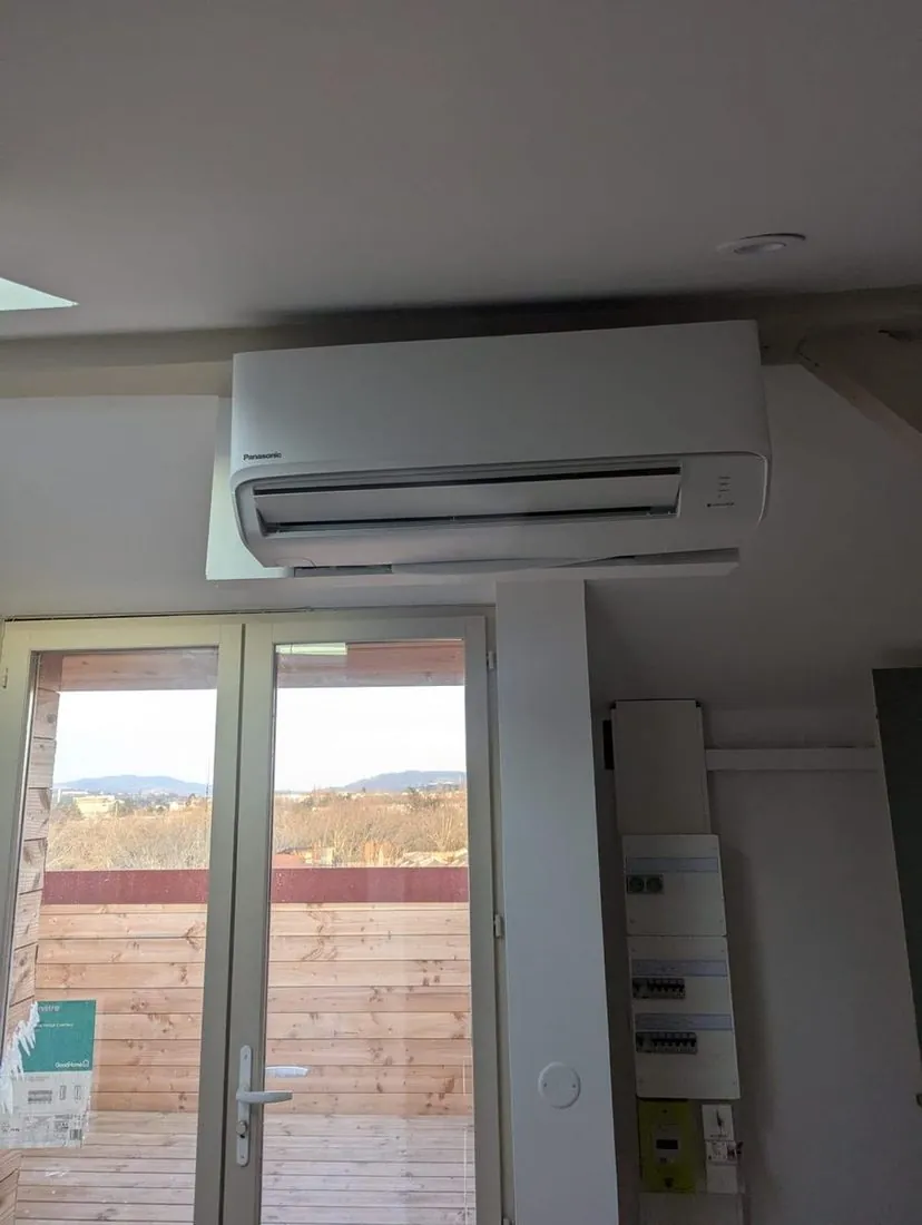 Climatiseur mural posé près d'une baie vitrée dans un séjour