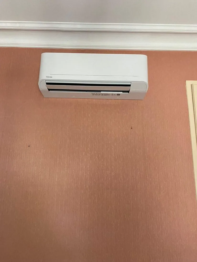 Split de climatisation posé sur un mur terracotta